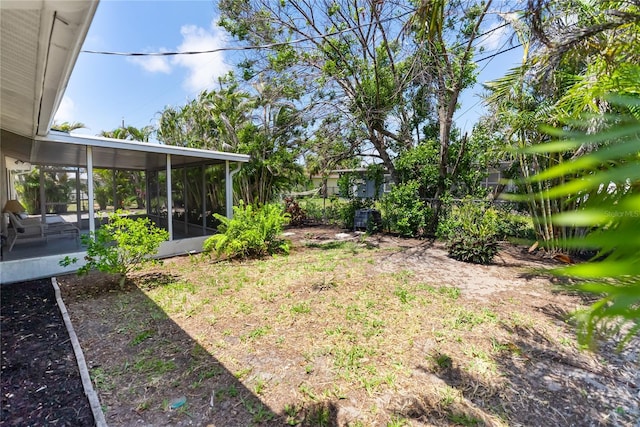 view of yard featuring fence and a sunroom