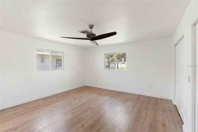 unfurnished bedroom featuring light wood-style flooring, a closet, a ceiling fan, visible vents, and baseboards