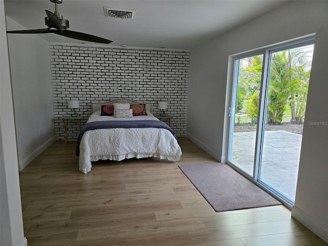 bedroom featuring visible vents, baseboards, access to outside, and light wood-style floors