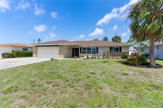 ranch-style house with concrete driveway, a front yard, brick siding, and a garage
