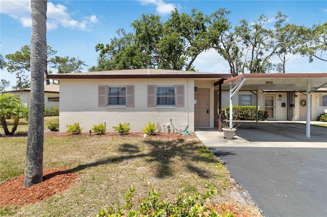2819 Swifton Dr Unit 9, Sarasota, FL 34231 - ranch-style home featuring a front lawn, an attached carport, and stucco siding
