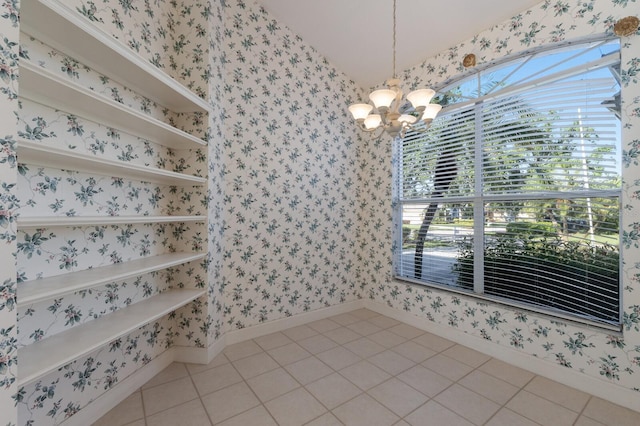 unfurnished dining area featuring a wealth of natural light, an inviting chandelier, baseboards, and wallpapered walls
