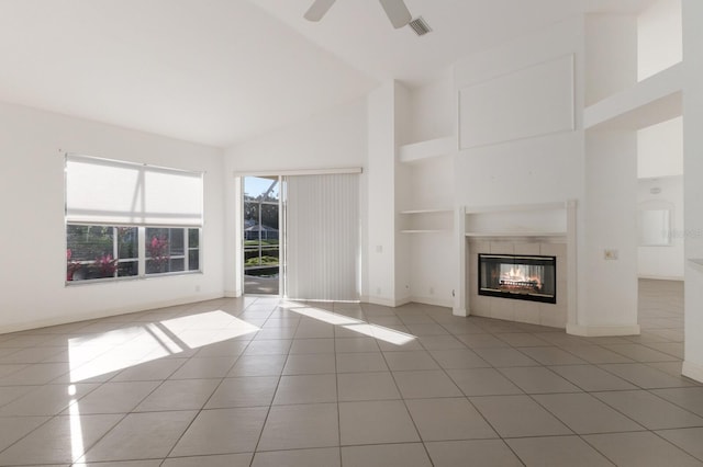 unfurnished living room with light tile patterned floors, baseboards, visible vents, a fireplace, and high vaulted ceiling