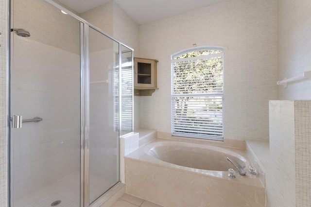 bathroom with tile patterned floors, a bath, and a stall shower