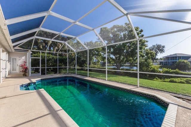 pool featuring a patio area, glass enclosure, and a lawn