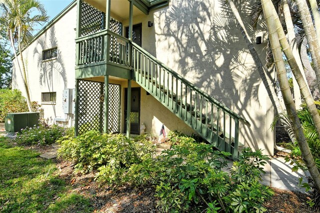1532 Pelican Point Dr Unit Ba139, Sarasota, FL 34231 - exterior space featuring stucco siding, stairway, and cooling unit