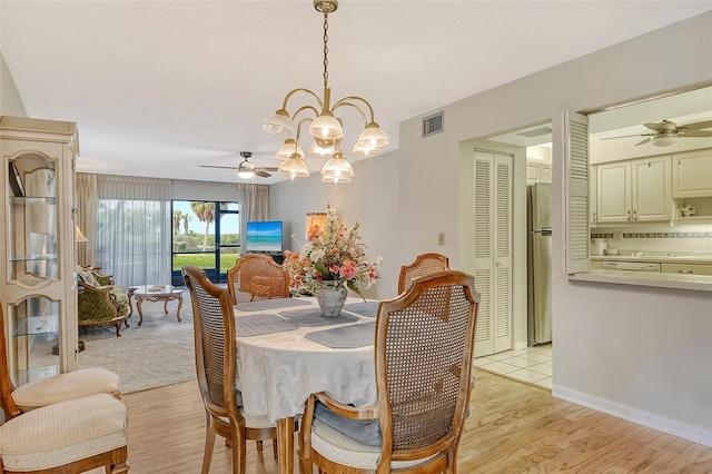 1532 Pelican Point Dr Unit Ba139, Sarasota, FL 34231 - dining room with light wood finished floors, visible vents, baseboards, and ceiling fan with notable chandelier