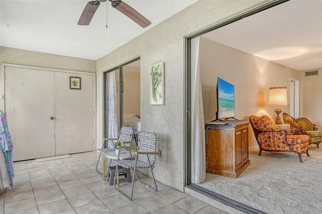 1532 Pelican Point Dr Unit Ba139, Sarasota, FL 34231 - sitting room with visible vents, light tile patterned floors, a ceiling fan, and a textured wall
