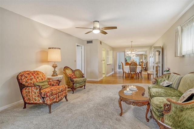 1532 Pelican Point Dr Unit Ba139, Sarasota, FL 34231 - carpeted living room featuring visible vents, baseboards, and ceiling fan with notable chandelier