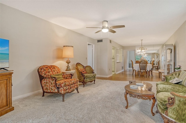 1532 Pelican Point Dr Unit Ba139, Sarasota, FL 34231 - living room featuring visible vents, baseboards, ceiling fan with notable chandelier, and light carpet