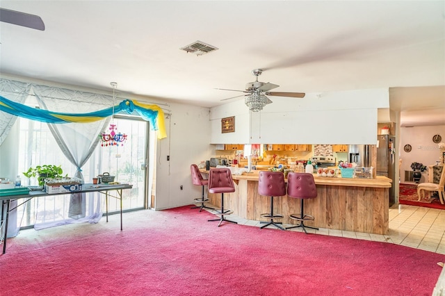 interior space with a ceiling fan, carpet flooring, and visible vents