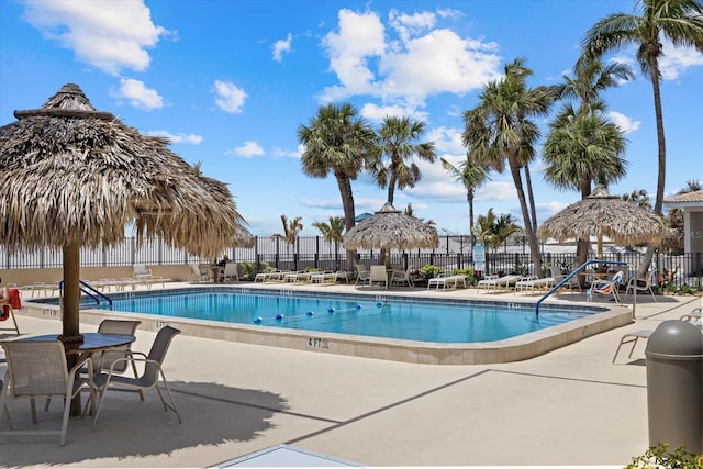pool with a patio and fence