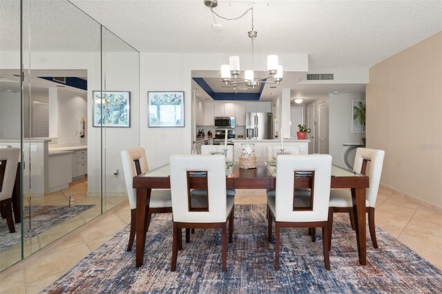 dining room featuring an inviting chandelier, light tile patterned flooring, a textured ceiling, and visible vents