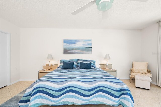 bedroom featuring baseboards, tile patterned flooring, a textured ceiling, and ceiling fan