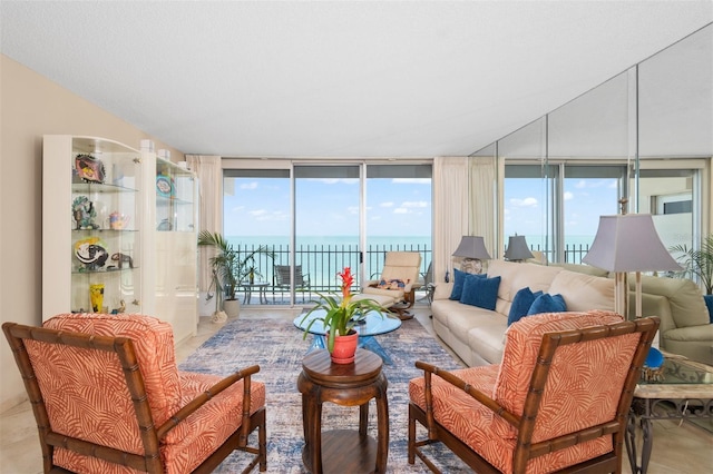 living room featuring a wall of windows and a water view