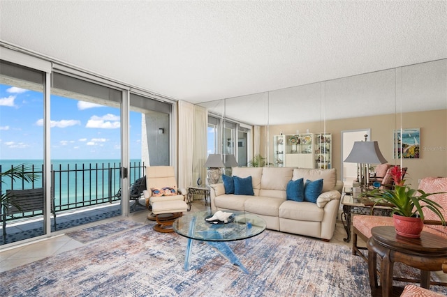 tiled living area featuring a textured ceiling and a water view