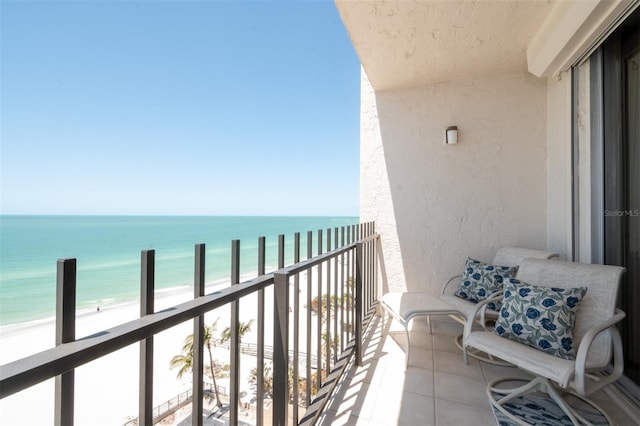 balcony featuring a beach view and a water view