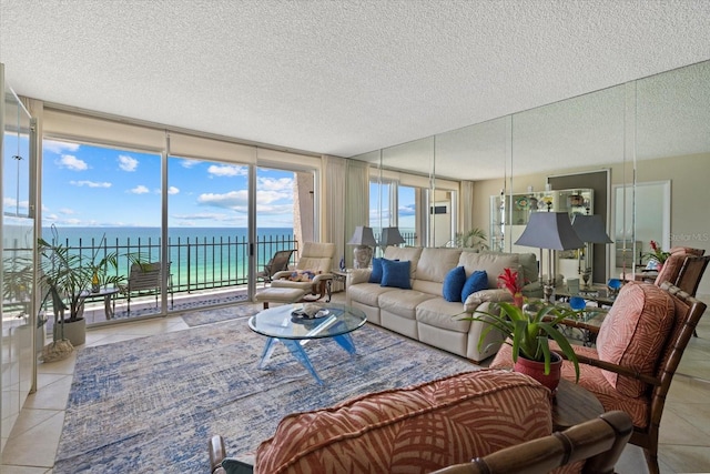 living area with a wall of windows, a textured ceiling, tile patterned floors, and a water view