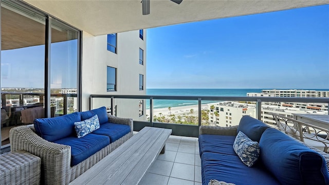 balcony with a water view, an outdoor hangout area, and a view of the beach