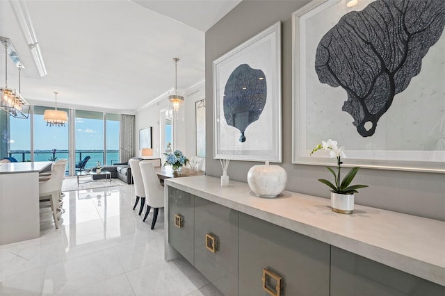 dining space with a water view, ornamental molding, light tile patterned floors, and expansive windows