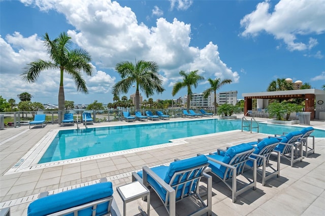 community pool with a patio and fence