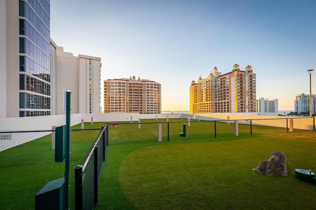 view of home's community with fence and a lawn
