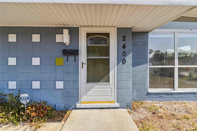 view of exterior entry featuring concrete block siding