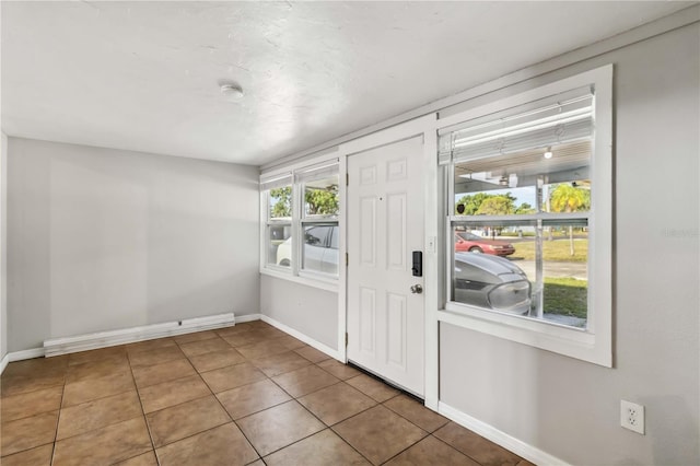 entryway featuring baseboards and tile patterned flooring