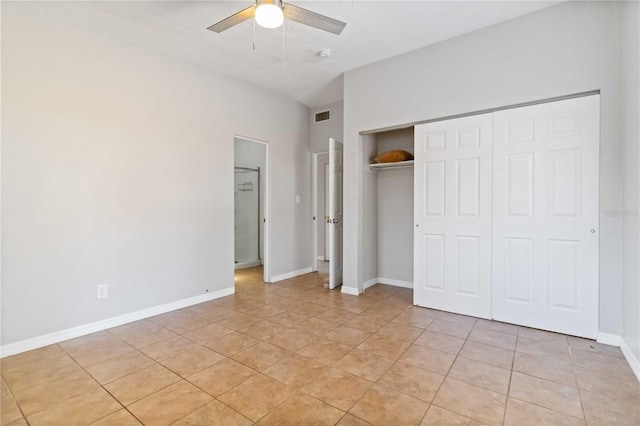 unfurnished bedroom with visible vents, a closet, light tile patterned flooring, baseboards, and ceiling fan
