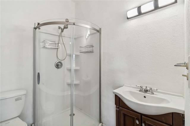full bathroom with toilet, a shower stall, and vanity