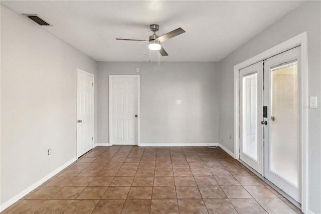 unfurnished room with a ceiling fan, baseboards, visible vents, and light tile patterned floors