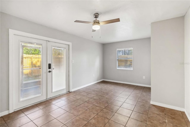 unfurnished room featuring a healthy amount of sunlight, baseboards, tile patterned flooring, and french doors