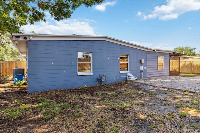 back of property featuring central AC, a patio area, and fence