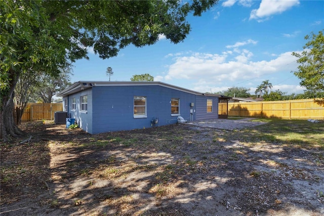 back of house with a fenced backyard and cooling unit