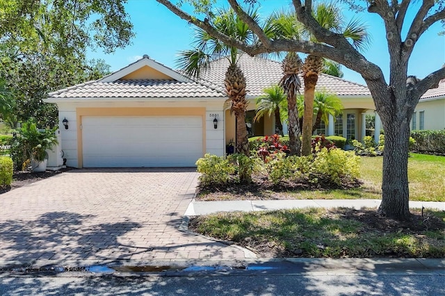 5881 Girona Pl, Sarasota, FL 34238 - view of front of house with a garage, decorative driveway, a tile roof, and stucco siding