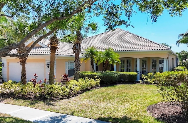 5881 Girona Pl, Sarasota, FL 34238 - view of front of home featuring a front lawn, stucco siding, a tiled roof, and an attached garage