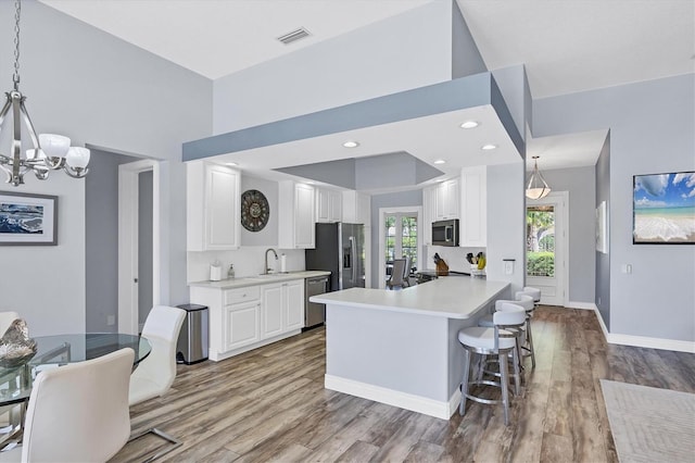 5881 Girona Pl, Sarasota, FL 34238 - kitchen with appliances with stainless steel finishes, a chandelier, wood finished floors, light countertops, and a sink