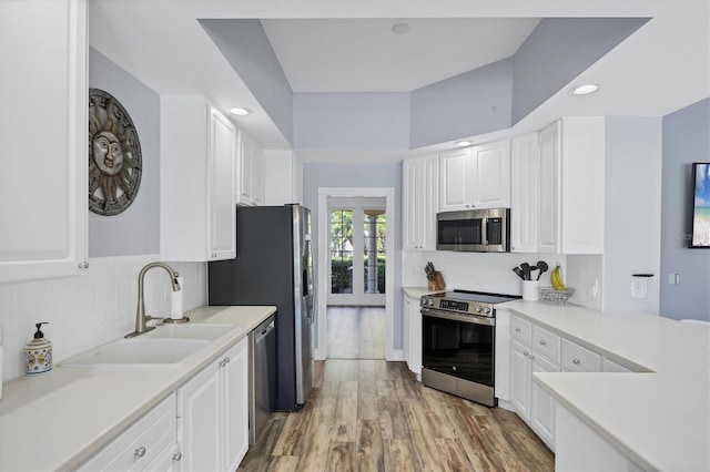 5881 Girona Pl, Sarasota, FL 34238 - kitchen featuring appliances with stainless steel finishes, a sink, white cabinets, french doors, and decorative backsplash