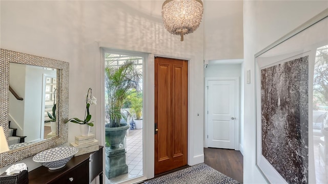 foyer with dark wood finished floors, a high ceiling, and stairs