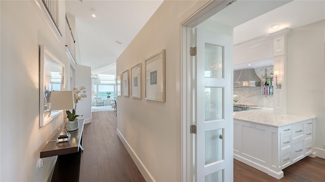hallway with dark wood finished floors and baseboards