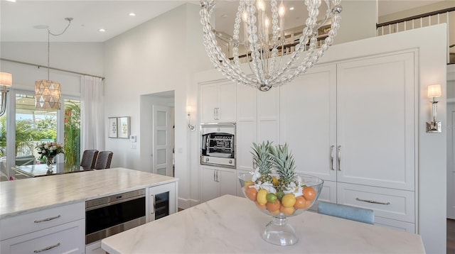 kitchen with decorative light fixtures, white cabinets, a notable chandelier, and wine cooler
