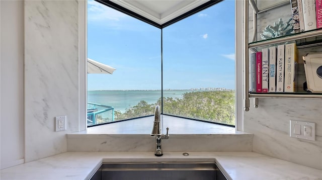 room details featuring a sink, a water view, and crown molding