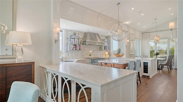 kitchen with hardwood / wood-style floors, a sink, beverage cooler, an inviting chandelier, and premium range hood