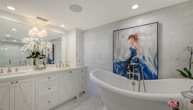 full bath with a notable chandelier, a sink, visible vents, and tile walls
