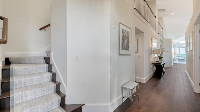 stairway with visible vents, baseboards, and wood finished floors
