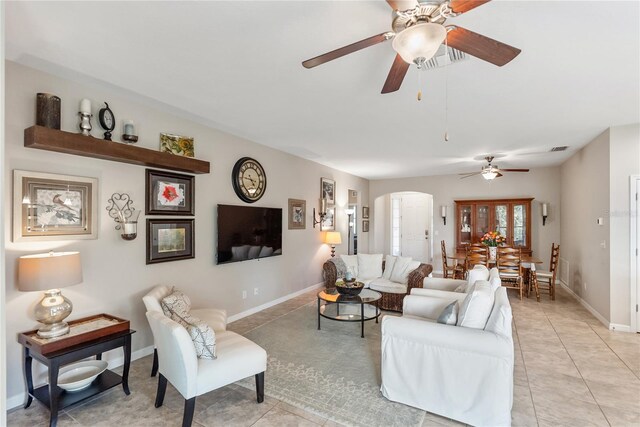 6124 35th Ct E, Bradenton, FL 34203 - living room with light tile patterned floors, ceiling fan, visible vents, baseboards, and arched walkways