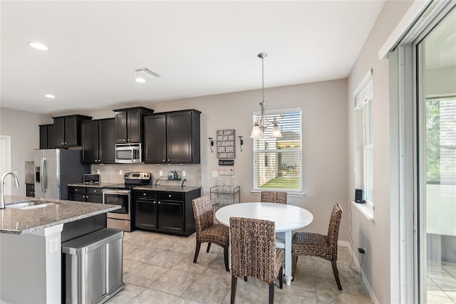 6124 35th Ct E, Bradenton, FL 34203 - kitchen featuring tasteful backsplash, stainless steel appliances, a healthy amount of sunlight, and a sink