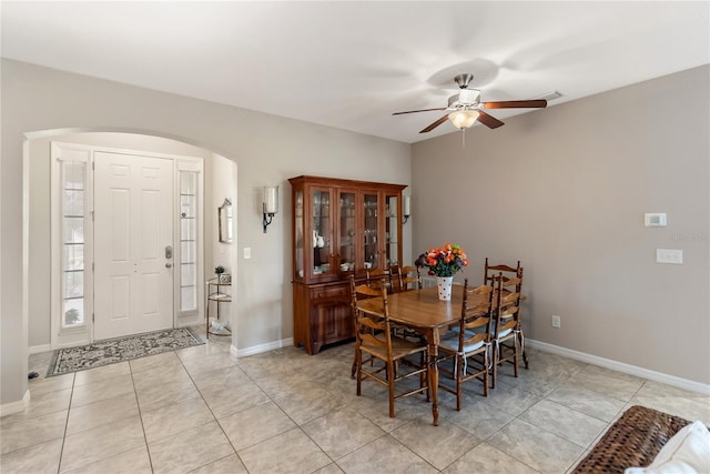 6124 35th Ct E, Bradenton, FL 34203 - dining space with light tile patterned floors, arched walkways, a ceiling fan, and baseboards