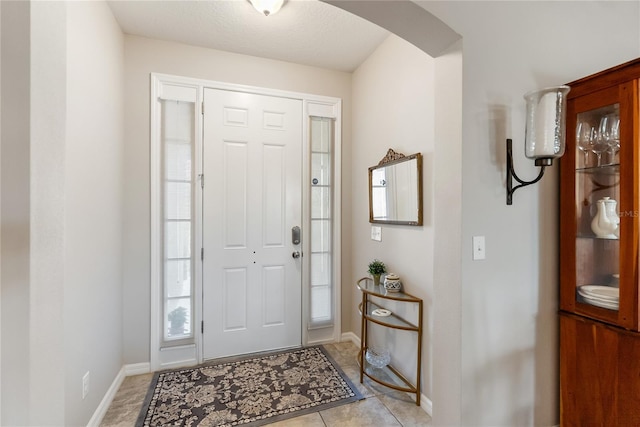 6124 35th Ct E, Bradenton, FL 34203 - foyer entrance featuring light tile patterned flooring, baseboards, and arched walkways