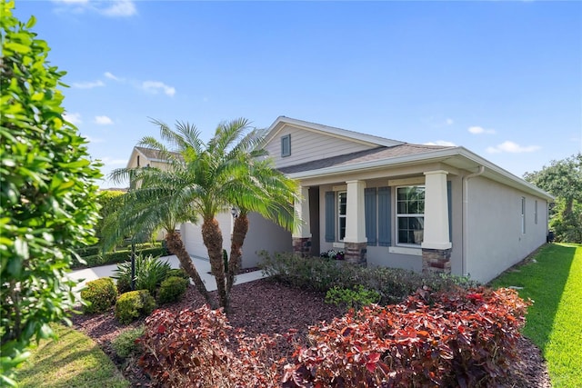 6124 35th Ct E, Bradenton, FL 34203 - view of home's exterior featuring stone siding, a garage, and stucco siding